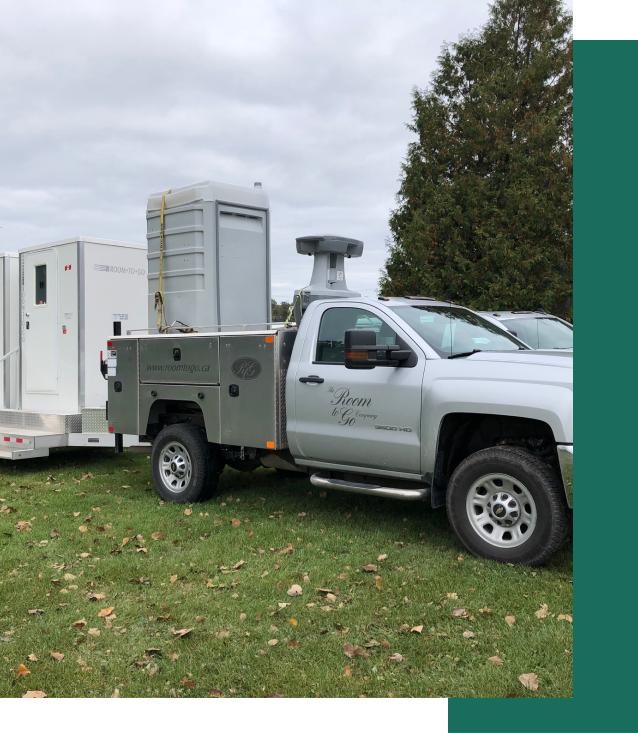 Truck delivering sanitary portable washrooms to construction site